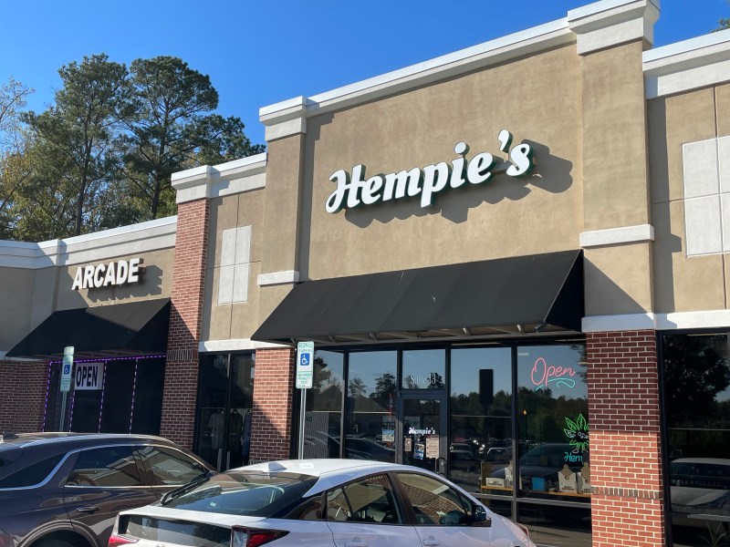 A brick storefront with white lettering that reads "Hempie's" and a black awning.
